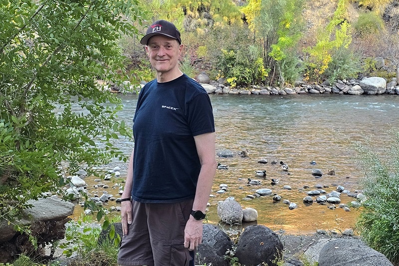 Craig stands by a river.