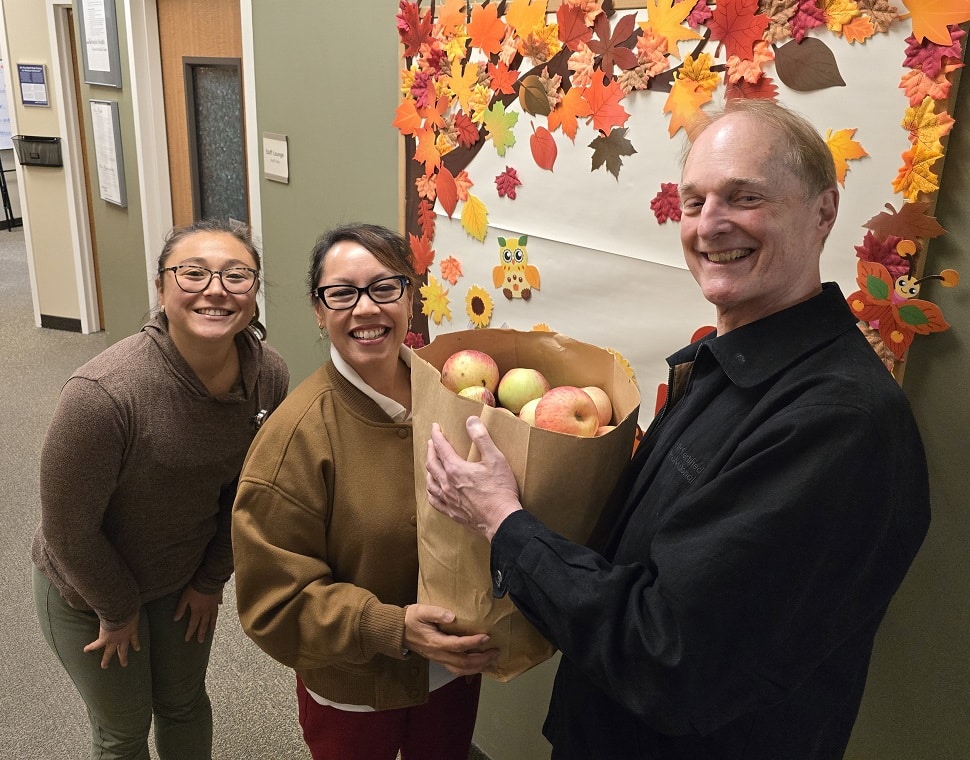 Craig gives a bag of apples to his cardiac rehabilitation team.